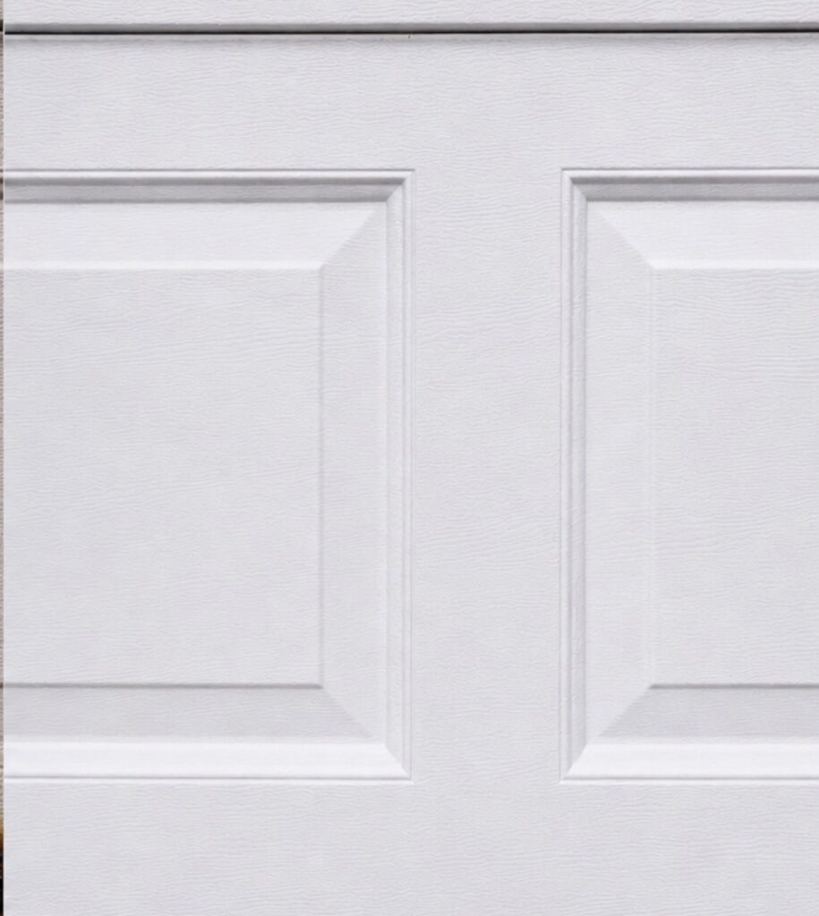 Close-up of a white insulated garage door panel with raised trim detail