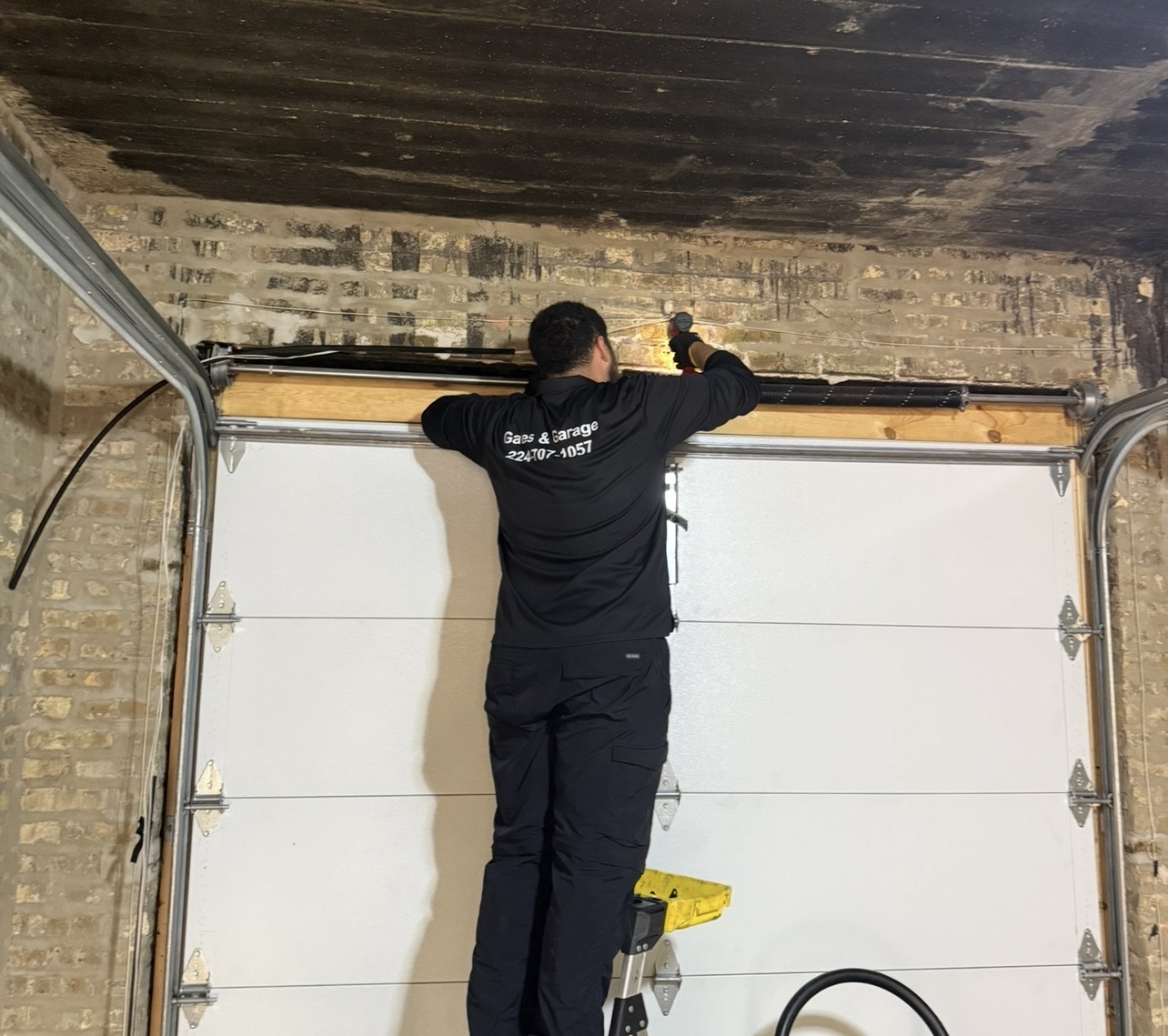 4Prime technician performing garage door spring and track maintenance