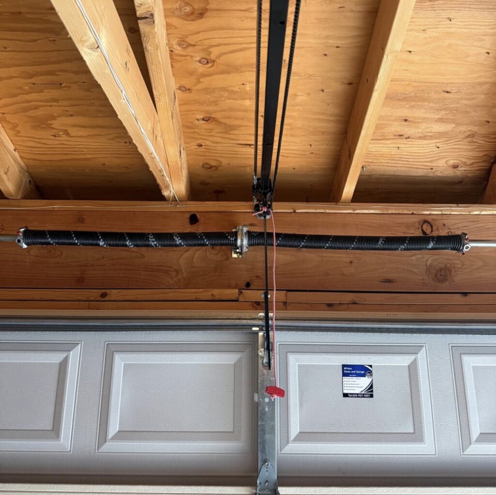 Garage door torsion spring mounted above a residential garage door serviced by 4Prime Gates and Garage