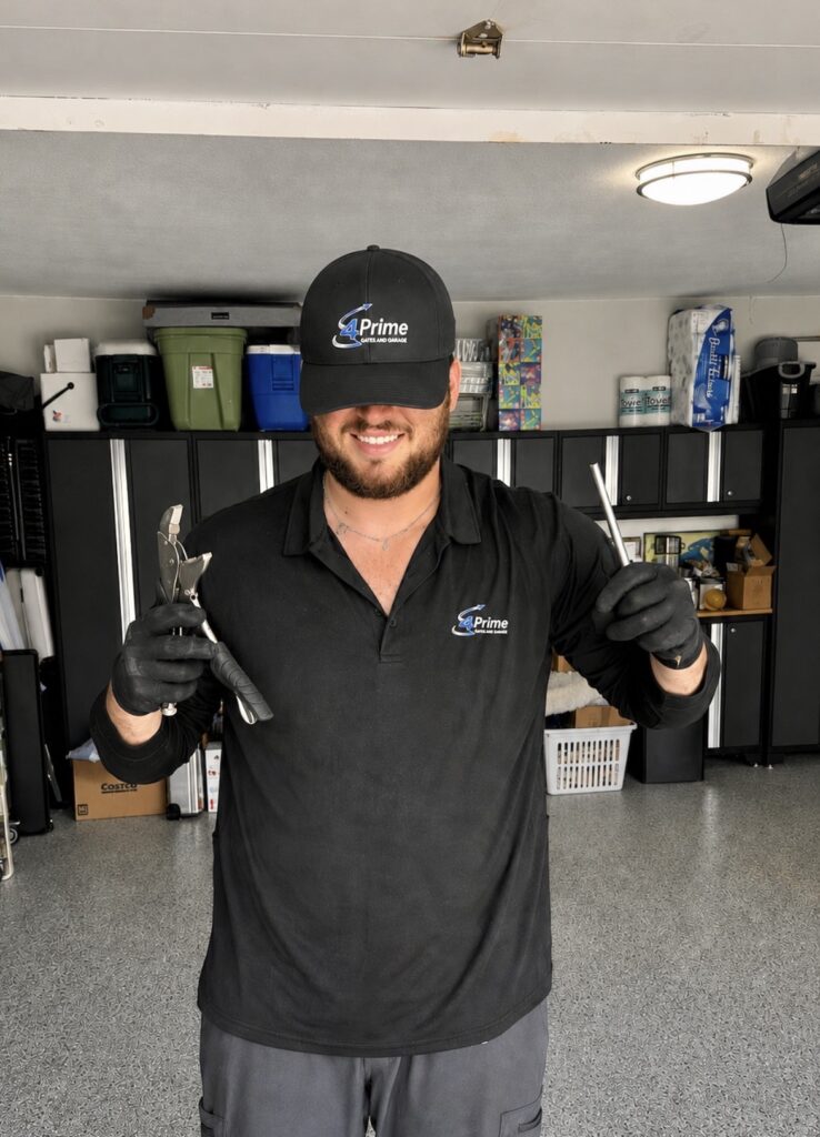 Smiling 4Prime Gates and Garage technician in branded uniform holding tools
