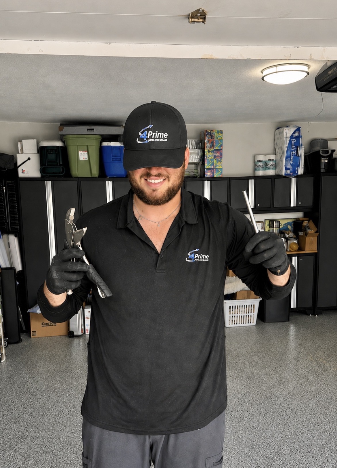 Smiling 4Prime Gates and Garage technician in branded uniform holding tools